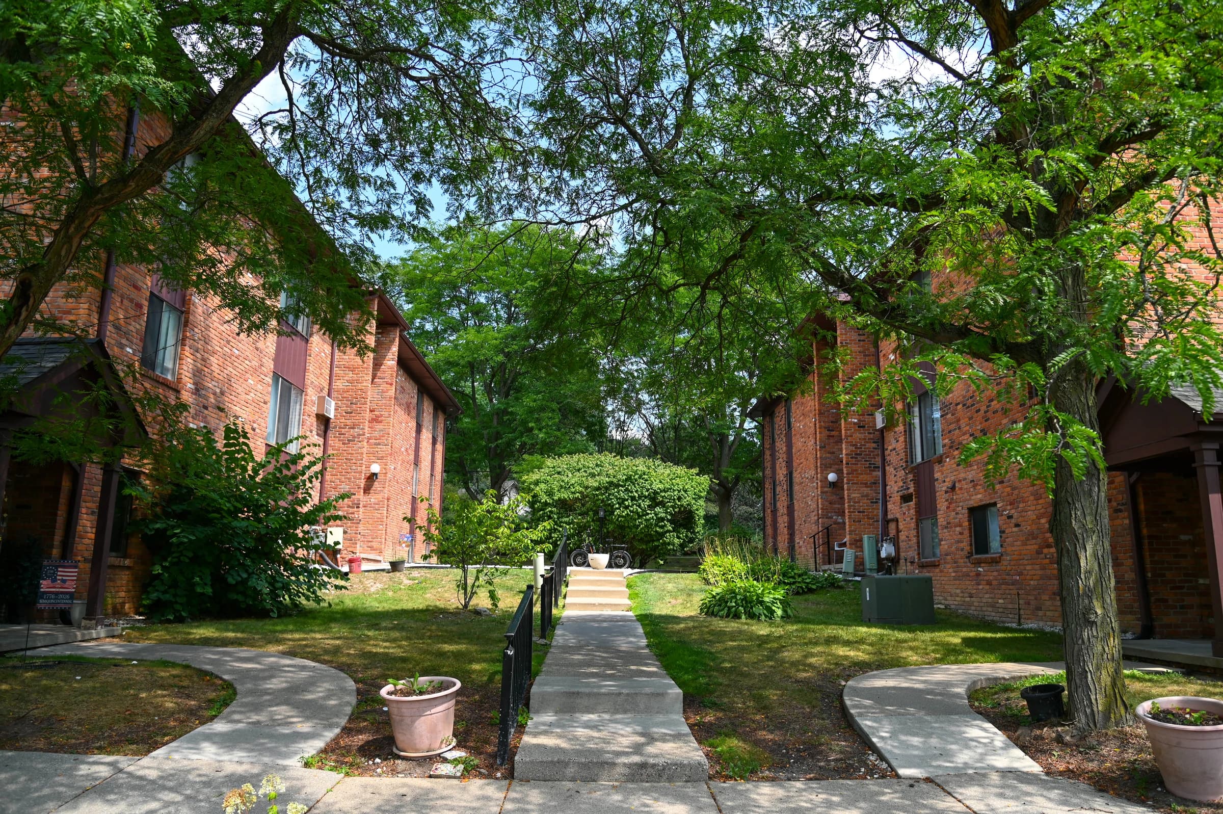 Tree-lined walkway between Village East apartment buildings